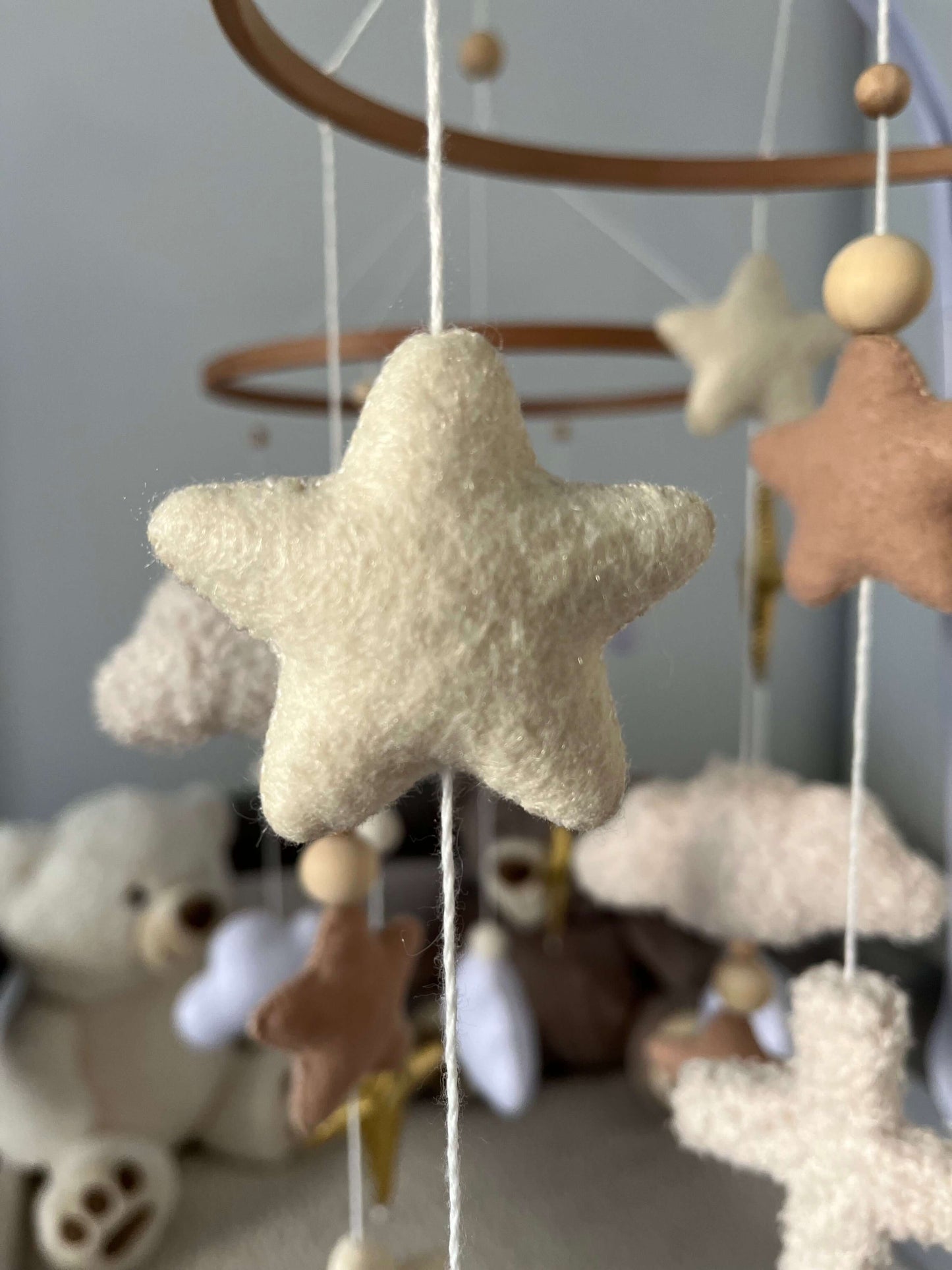 Felt star mobile charm for children's nursery, featuring soft colors and peaceful design elements.