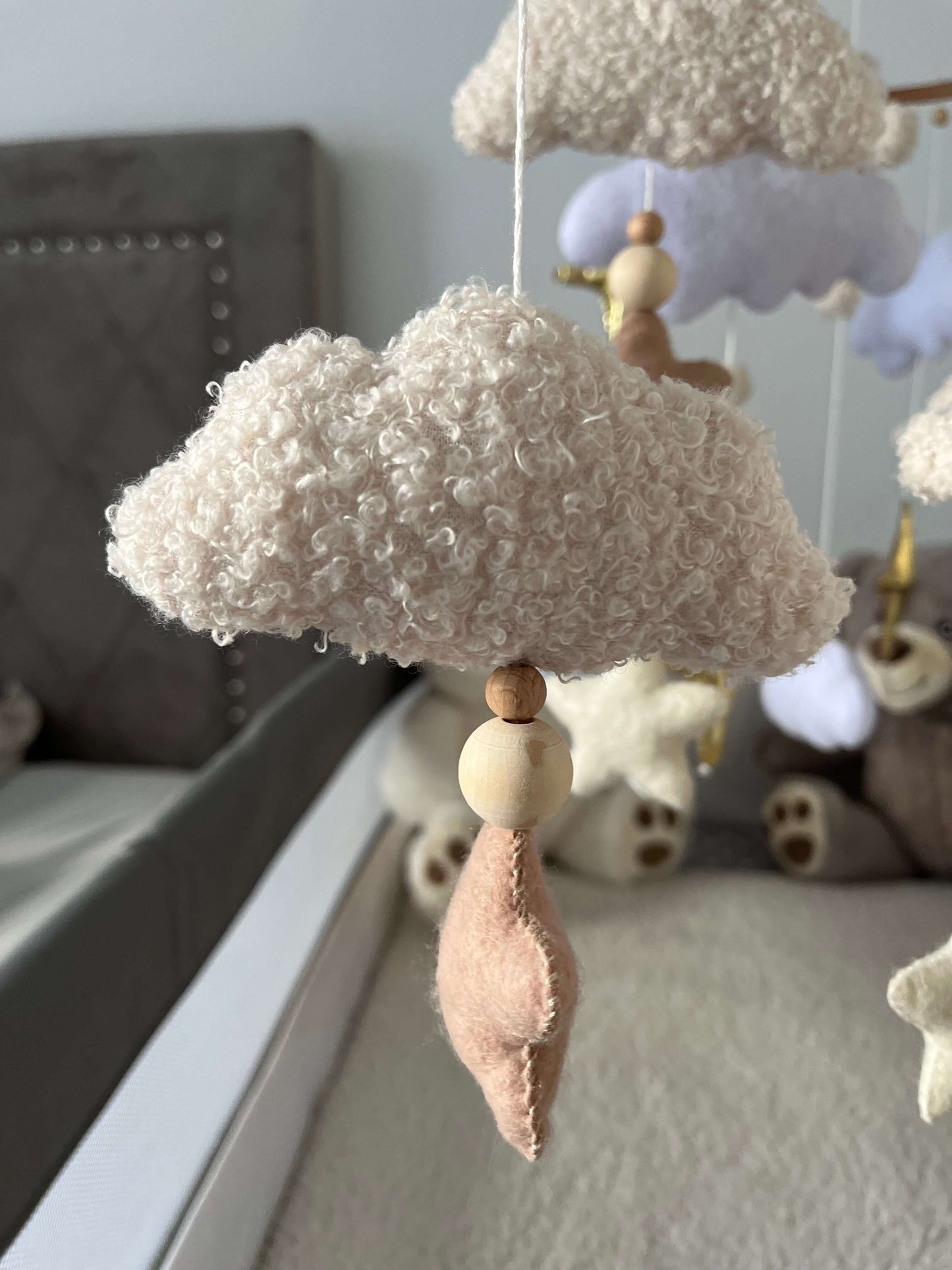 Mobile with soft, textured clouds and wooden beads, creating a peaceful nursery atmosphere.