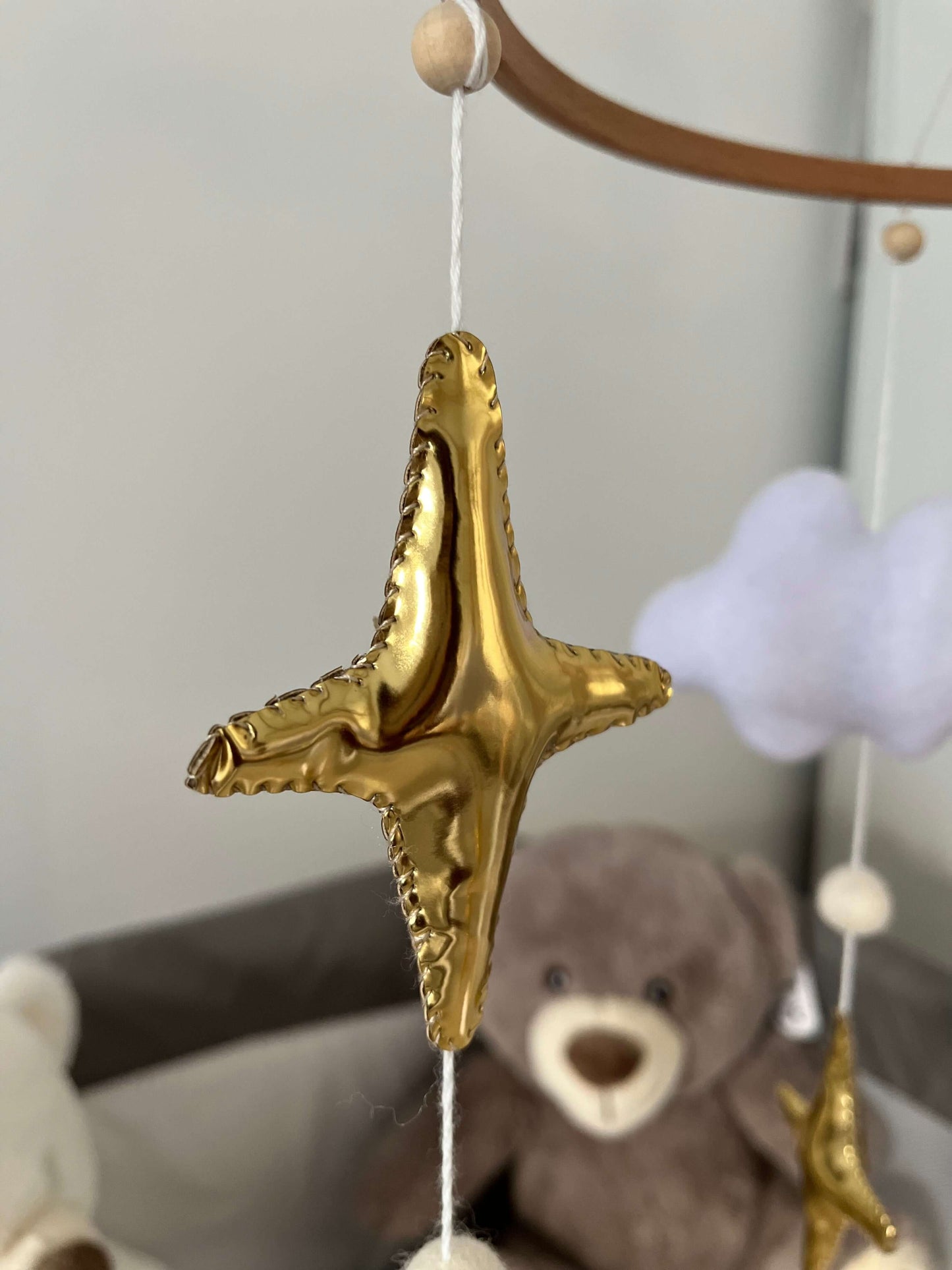 Golden star mobile decoration symbolizing hope and faith for a child's nursery.